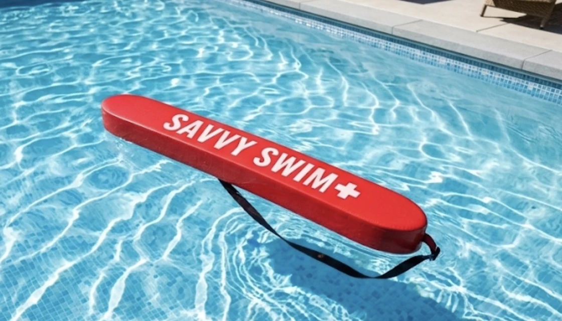 Red Savvy Swim rescue tube on the pool deck